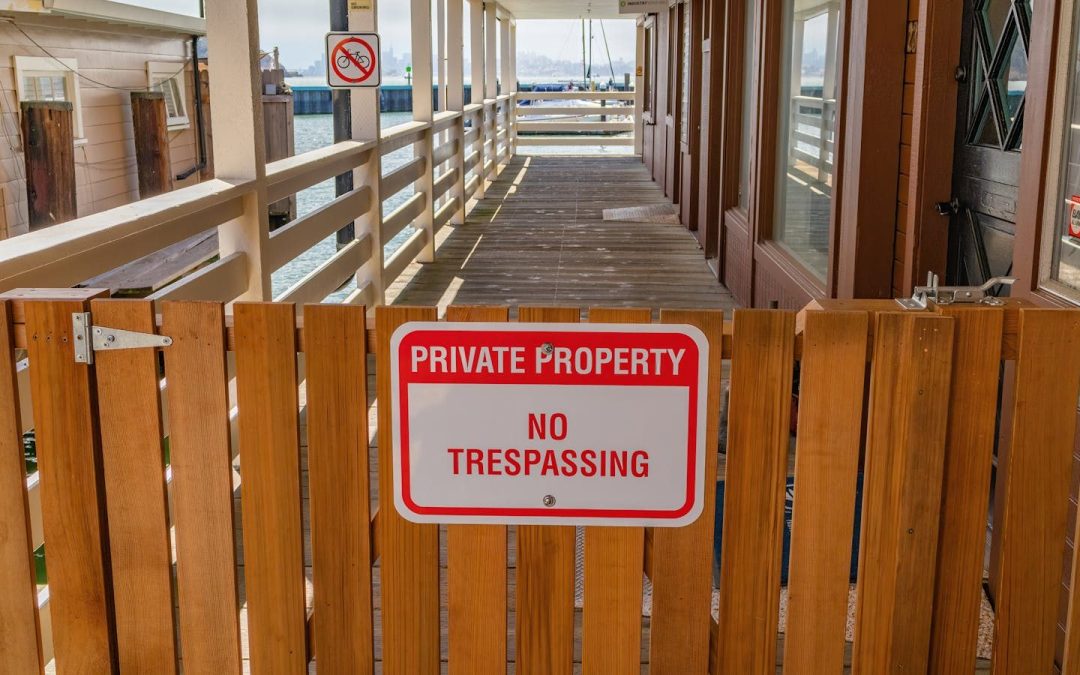Wooden gate with a private property no trespassing sign in an outdoor setting.