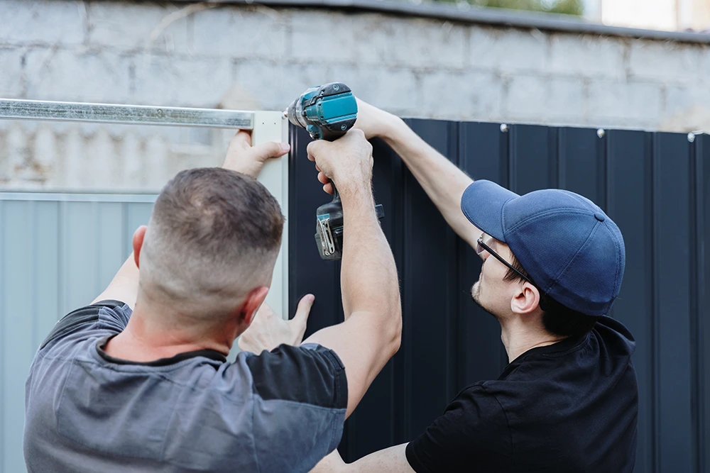 Fence installation service building a durable wooden fence for a homeowner.